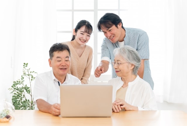 家族でパソコンを見ている写真